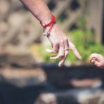 Grandmaother And Childs Hands About To Touch